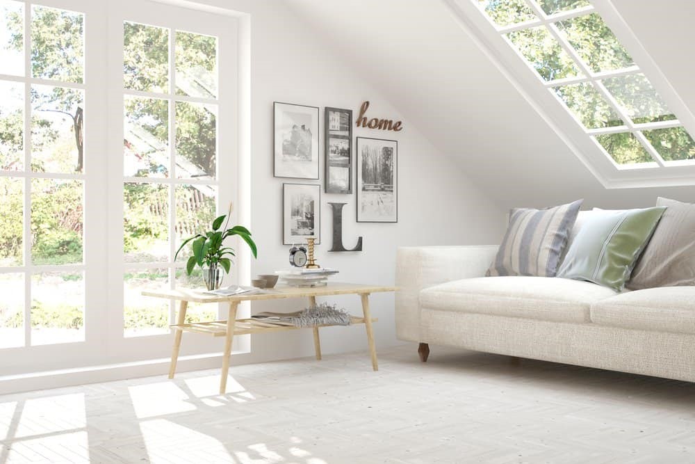 Gác mái có cửa sổ trời, sofa sáng màu và bộ tranh đen trắng treo tường