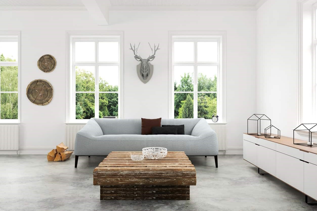 Phòng khách phong cách Bắc Âu có sofa xám, bàn gỗ tái chế và tranh đầu hươu