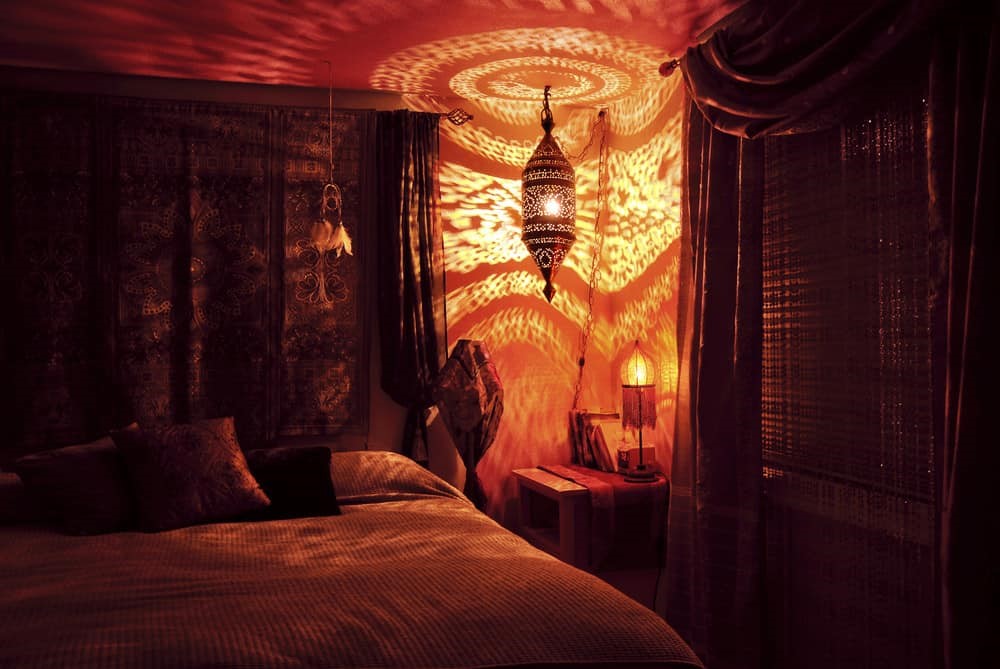 Phòng ngủ đỏ có đèn lục lạc Ma Rốc treo thả bóng hoa văn lên tường