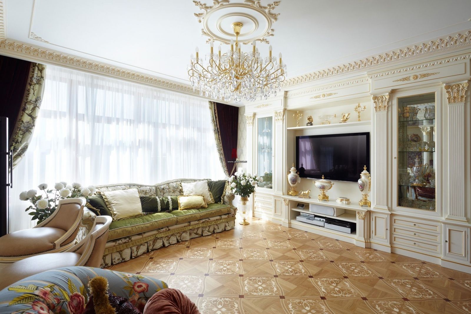Phòng khách sang trọng với sofa họa tiết, đèn chùm pha lê và kệ tivi chạm khắc.