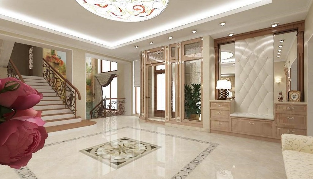 Sảnh nhà có cầu thang uốn lượn, sàn đá cẩm thạch và trần đèn trang trí.